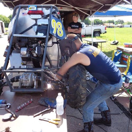 WVU makes repairs to the rear suspension in the Pitts at the 2017 Baja SAE Competition.