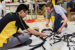 Students working on a vehicle wiring harness